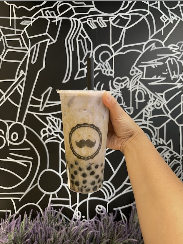 milk tea in hand with background 6.